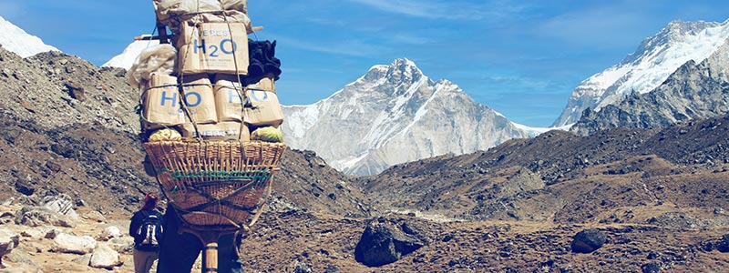 Sherpa trägt eine große Last auf dem Rücken