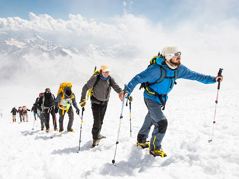 CT-Emission-01 Eine Gruppe von Bergsteigern steigt auf den Gipfel eines schneebedeckten Berges.